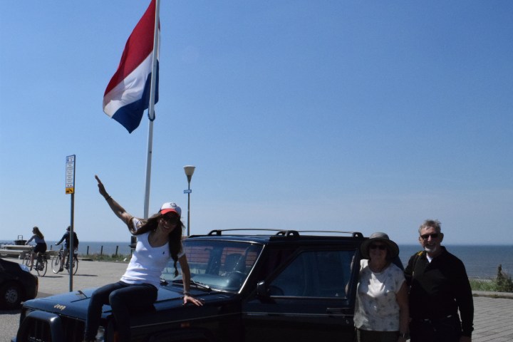 Three people next to a Jeep