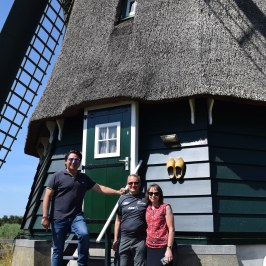 Three people in front of a windmill