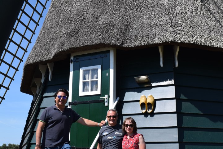 Three people in front of a windmill