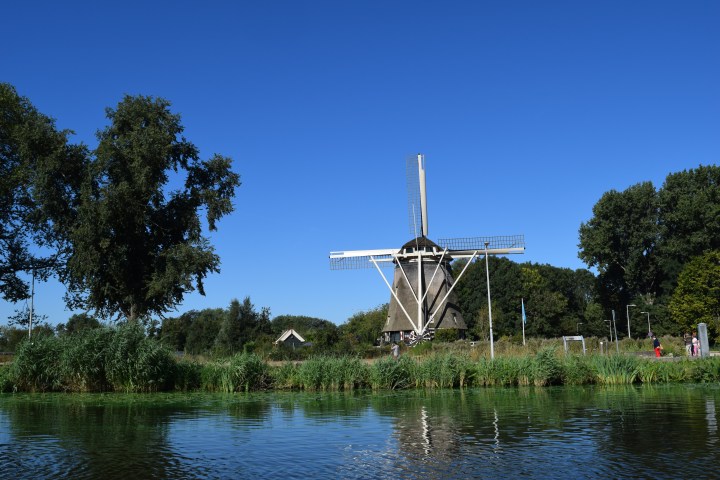A windmill next to a lake