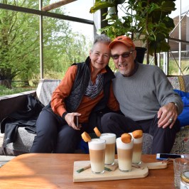 Two people sitting on a couch with Latte Macchiatos in front of them