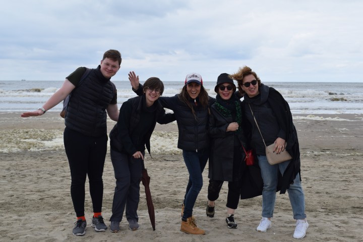 Five people standing on the beach